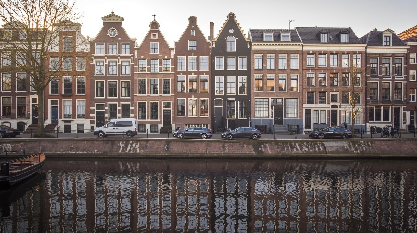 Classic Dutch houses along a canal in Amsterdam, symbolizing a move to the Netherlands.